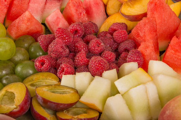 Miscela di frutta. Pesca, uva, mela, anguria, melone, lampone, susina. Succosa e matura pezzi di frutta primo piano
. - Foto, immagini