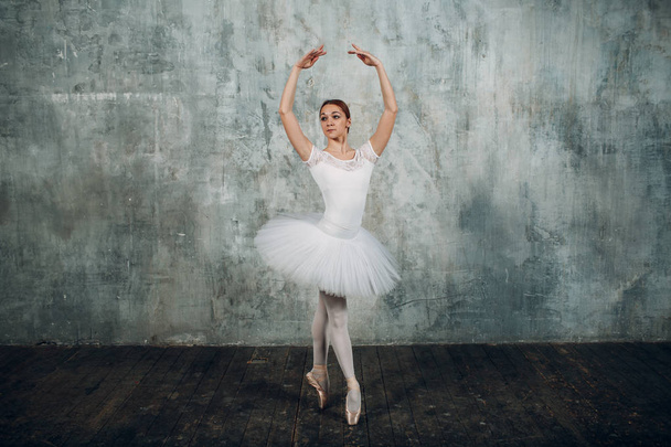 Ballerina female. Young beautiful woman ballet dancer, dressed in professional outfit, pointe shoes and white tutu. - Photo, Image