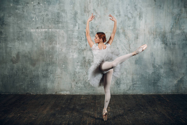 Balerina. Profi felszerelés, a pointe cipők és a fehér szoknyában öltözött fiatal gyönyörű nő balett-táncos. - Fotó, kép