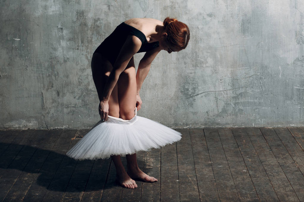 Ballerina pukeutuu valkoiseen tutuun. Nuori kaunis nainen baletti tanssija
, - Valokuva, kuva