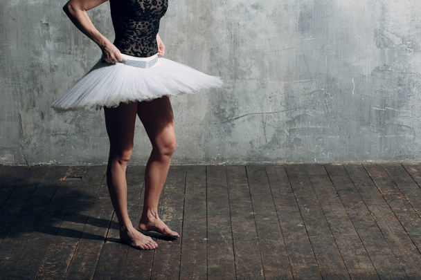 Bailarina femenina. Joven hermosa bailarina de ballet, vestida con traje profesional, zapatos puntiagudos y tutú blanco
. - Foto, Imagen