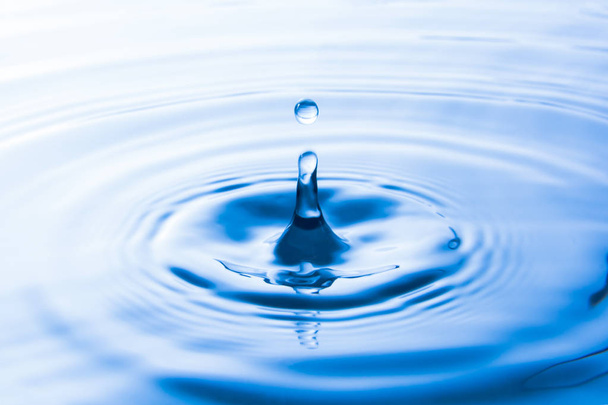 Water drop falling into water make waves. Water splash or water drop background.  - Photo, Image