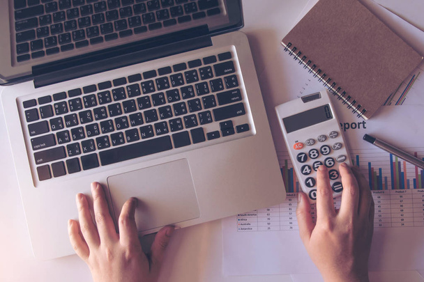 close up donna utilizzando calcolatrice e laptop su carta grafico dati con fare finanza in ufficio. vista dall'alto
 - Foto, immagini