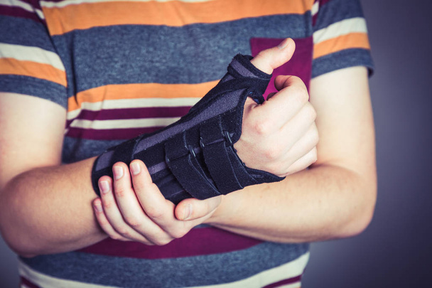 Man with hand in orthopedic black orthosis - Foto, immagini