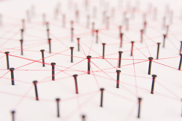 Varlıklar, sosyal medya, İletişim Ağı, iki ağ arasındaki bağlantı bağlantı. Siyah çivi ve kırmızı iplik tarafından oluşturulan birbirine bağlı beyaz kağıt üzerinde ağ simülasyonu - Fotoğraf, Görsel