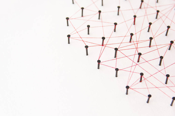 Зв'язування сутностей, соціальних мереж, комунікаційної мережі, зв'язку між двома мережами. Мережеве моделювання на білому папері, пов'язане разом, створене чорним цвяхом та червоною ниткою з простором для копіювання
 - Фото, зображення