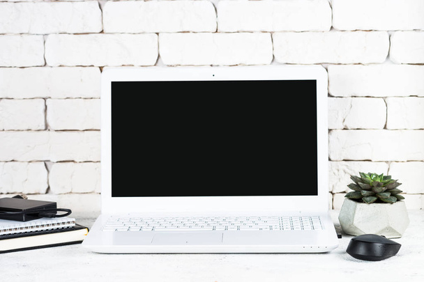 Büroarbeitsplatz mit Laptop auf weißem Schreibtisch. - Foto, Bild