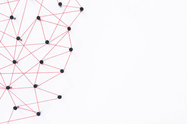 Concepto de conexión de redes: red conectada con hilo rojo sobre papel blanco con espacio de copia. Conexión de simulador redes sociales, internet, comunicación de personas, entidades vinculantes
 - Foto, imagen