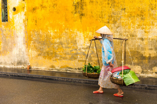 HOI AN, QUANG NAM, VIETNAM - ENERO 03, 2019: Vendedora callejera vietnamita En Hoi un Vietnam en la antigua ciudad HoiAn
 - Foto, Imagen
