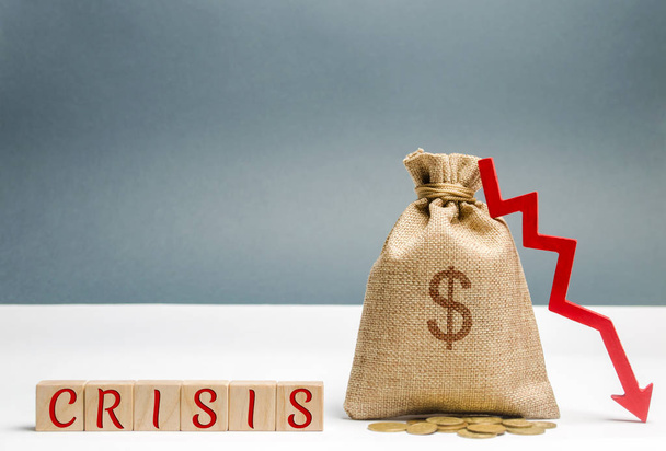 Wooden blocks with the word Crisis and money bag. The concept of financial and economic crisis. capital outflow. sabotage of the economy. bankruptcy. cash loss. pay cut and lack of funds - Photo, image