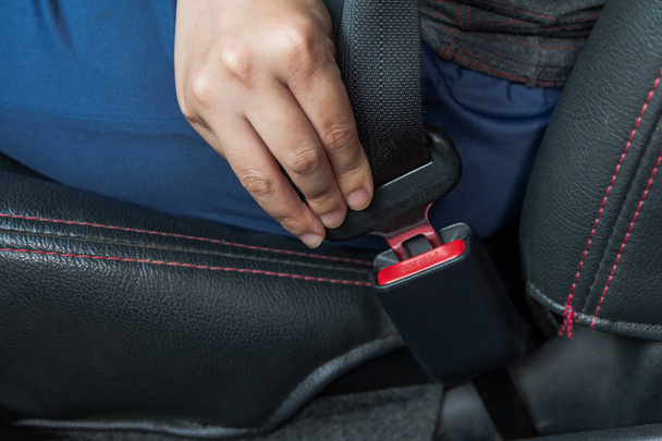 Car seat belt. woman fastens the seat belt on car Safe driving. Safety belt in hand.  - Fotó, kép