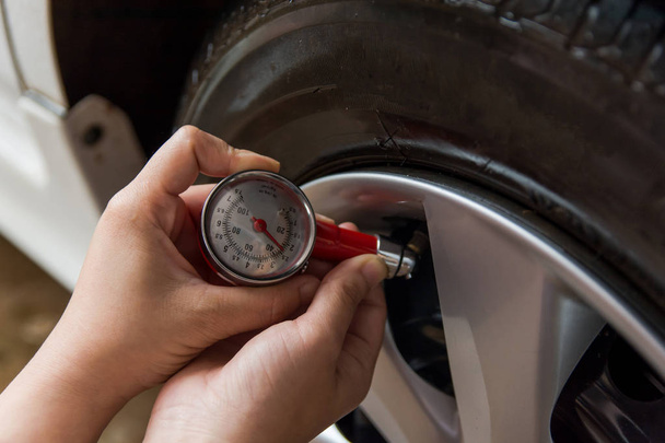 Μετρητής πίεσης ελαστικών: χέρι εκμετάλλευση μανόμετρο ελέγχου πίεσης αέρα για το ελαστικό αυτοκινήτου. Ασφαλής οδήγηση. - Φωτογραφία, εικόνα