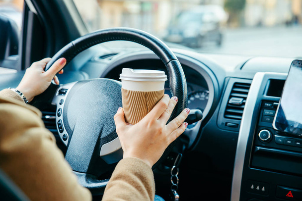 nő, autó vezetés, és kávét iszik. telefon navigációs. életmód - Fotó, kép