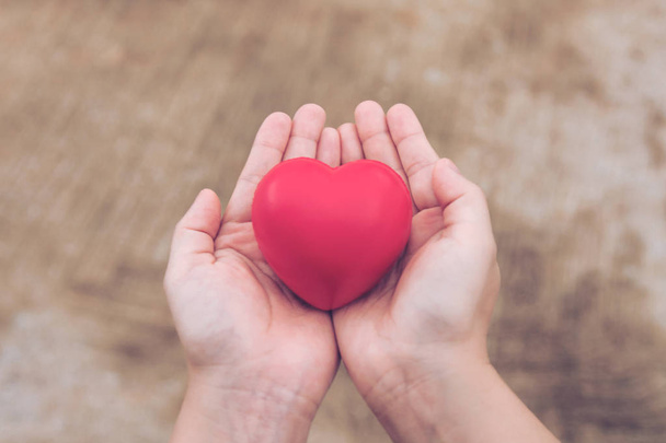 Czerwone serce piłkę: stres reliever piana piłka kształt czerwone serce na dłoni kobieta. Prezent na Walentynki - Zdjęcie, obraz