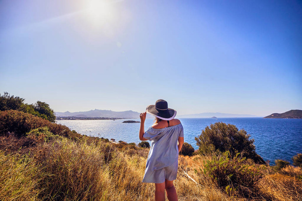 schöne Frau mit Strandhut genießt Meerblick mit blauem Himmel bei sonnigem Tag in Bodrum, Türkei. Urlaub im Freien Seenlandschaft Sommerreisekonzept - Foto, Bild