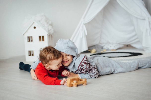 Two funny boys play together. Cute happy brothers smiling and having fun - Fotografie, Obrázek