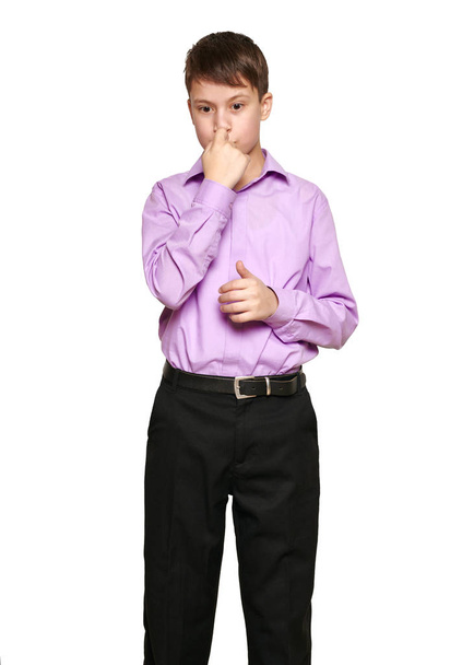 Jongen die zich voordeed op witte achtergrond, zwarte broek en paars shirt - Foto, afbeelding