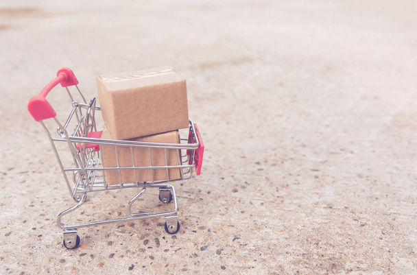 Shopping concept: kartons of papier vakken in winkelwagen op betonnen vloer. online winkelende consumenten kunnen thuis en levering dienst winkelen. met kopie vriendelij - Foto, afbeelding