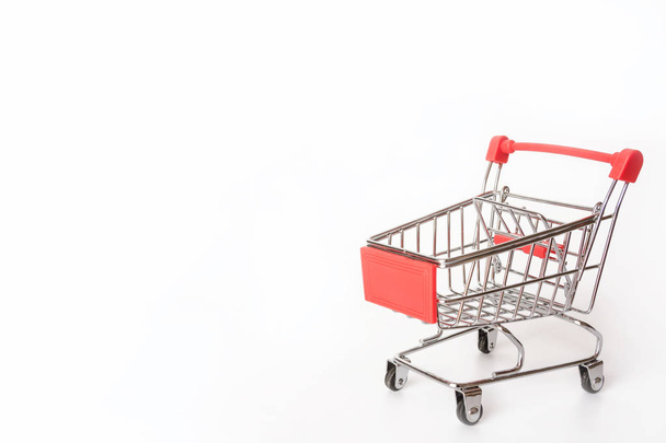 Carrito de compras rojo o carrito de supermercado sobre fondo blanco con espacio de copia
 - Foto, imagen
