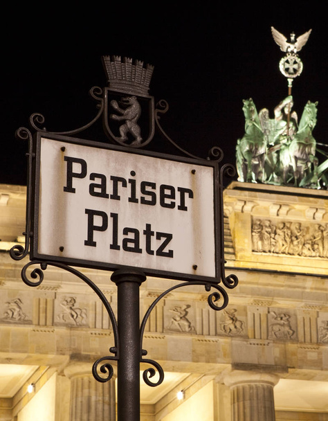 Un cartello stradale Pariser Platz con l'iconica Porta di Brandeburgo sullo sfondo, a Berlino, Germania
. - Foto, immagini
