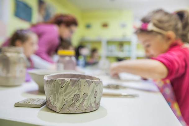 Petits artistes travaillant avec de l'argile à l'atelier de poterie. - Photo, image