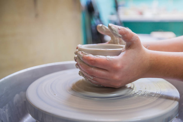 Child potters hands molding clay on wheel at workshop. - Valokuva, kuva