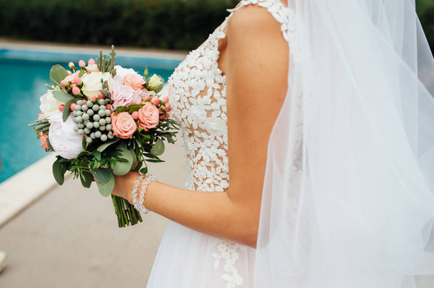 closeup of bride hands holding beautiful wedding bouquet - 写真・画像