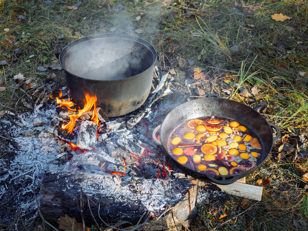 グリュー ワインを準備する鍋。赤ワインにシナモンとはちみつとクローブ火で調理 - 写真・画像