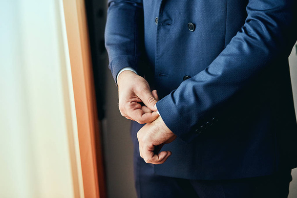 Empresário usa uma jaqueta, mãos masculinas close-up, noivo se preparando pela manhã antes da cerimônia de casamento. Moda Masculina
 - Foto, Imagem
