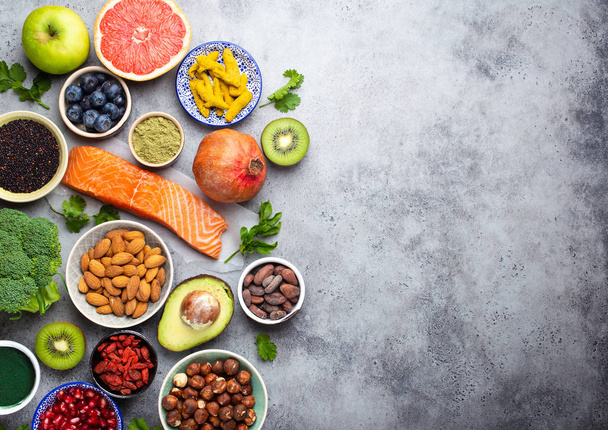 健康製品、スーパー フードの選択: サーモン、フルーツ、野菜、果実、剛、スピルリナ、抹茶、キノア、チア、コピー スペース付きナット。きれいな概念を食べて、背景が灰色、トップ ビューをクローズ アップ - 写真・画像