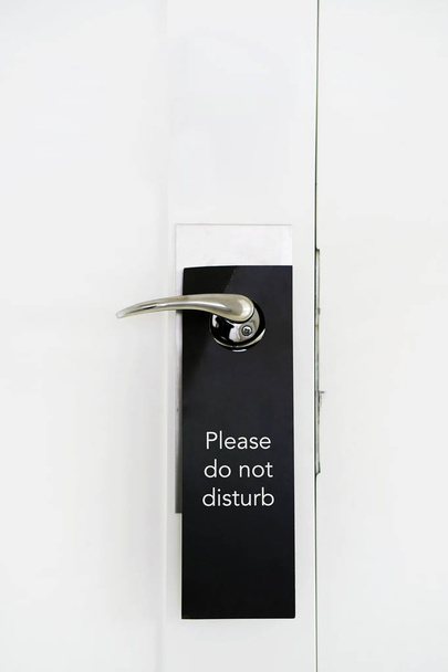 Do Not Disturb sign hang on door knob. Do No Disturb sign at hotel room door. Close-up - Foto, Imagem