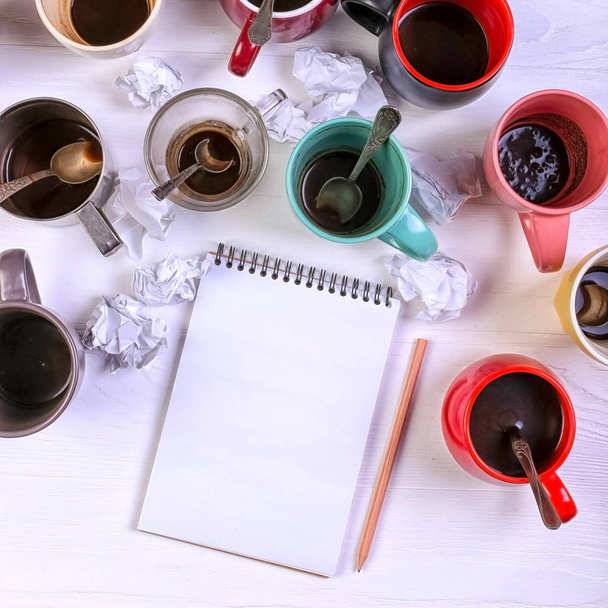 Empty dirty coffee cups, different colors on table and notebook for writing letter. Concept caffeine dope, lack of energy to solve the problem. Copy space. - 写真・画像