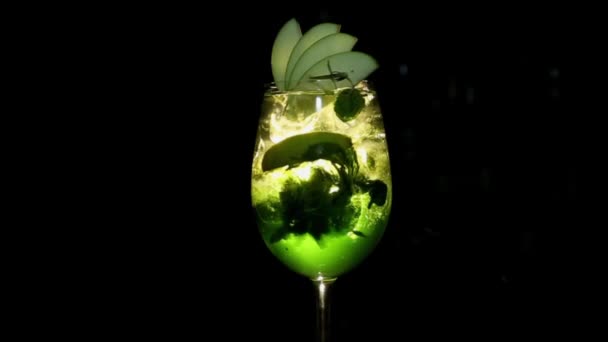 Green cocktail met Apple likeur draait op een zwarte achtergrond. - Video