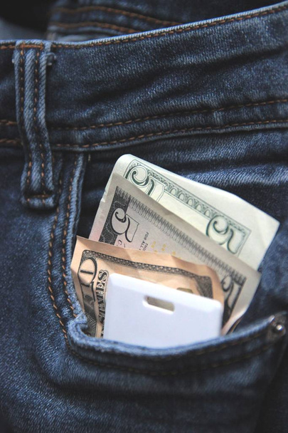 Soldi e chiave di carta in una tasca di jeans azzurri di impiegato di ufficio che si affretta su una pausa di pranzo da vicino. Concetto di fast food nella grande città beat. sfocatura
 - Foto, immagini