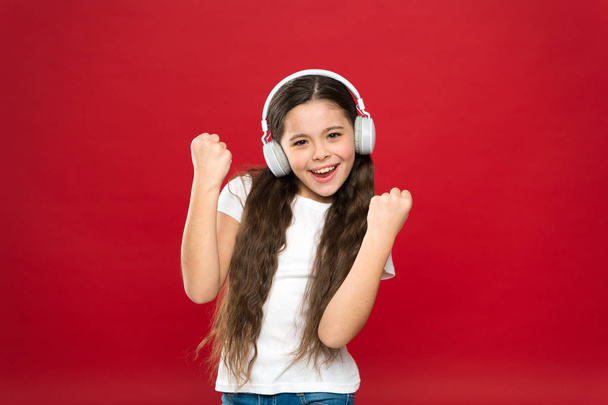Music taste. Music plays an important part lives teenagers. Powerful effect music teenagers their emotions, perception of world. Girl listen music headphones on red background. Modern gadget concept - Fotó, kép