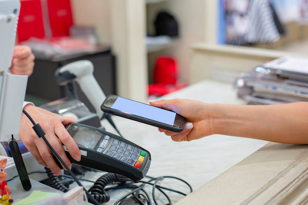 Bezdrátové platby pomocí smartphone a technologií Nfc. Zblízka. Samice zákazník platící s chytrý telefon v obchodě. Detailní záběr nakupování - Fotografie, Obrázek
