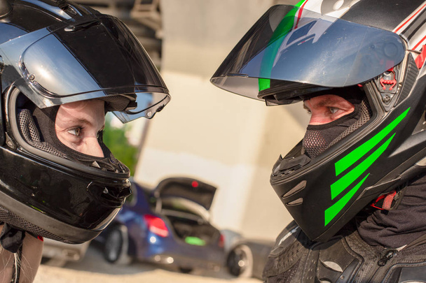Portrait of bikers man and woman in helmets look at each other. Motorcycle love concept. Extreme riders - Foto, Imagem