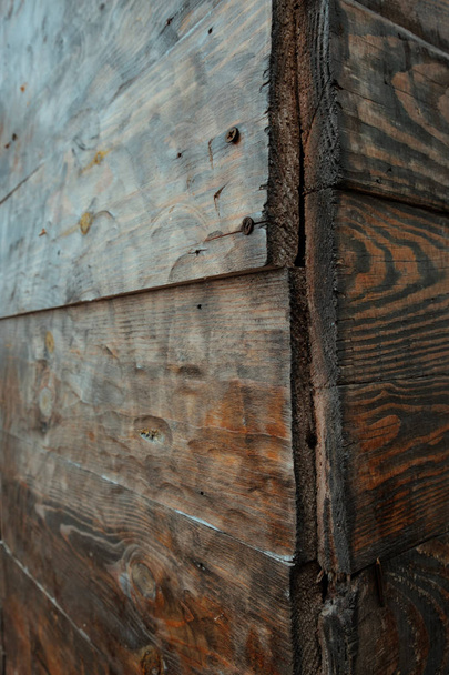 De vergrote weergave van de hoek van een rotte muur gemaakt van hout, houten textuur achtergrond - Foto, afbeelding