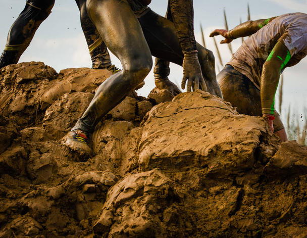 アクションで泥だらけの障害物競走のランナー。泥を実行 - 写真・画像