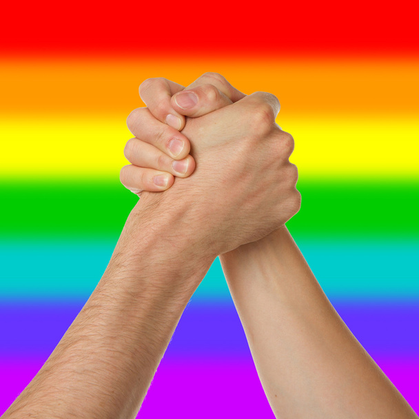 Homem e mulher em braço wrestlin, padrão de bandeira do arco-íris
 - Foto, Imagem