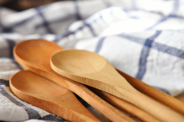 A close up image of several wooden spoons on a blue and white tablecloth.  - Photo, Image