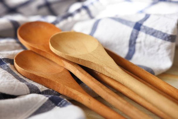 A close up image of several wooden spoons on a blue and white tablecloth.  - Photo, Image