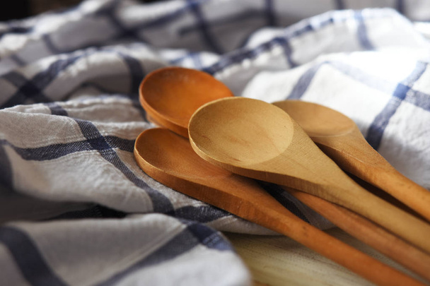 Un'immagine ravvicinata di diversi cucchiai di legno su una tovaglia blu e bianca
.  - Foto, immagini