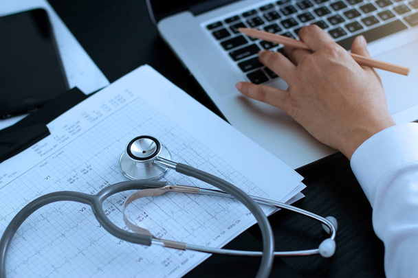 Medicine doctor. Stethoscope with heartbeat report and doctor analyzing checkup on laptop in health medical laboratory,  medical network and global connection. Medical technology and heart disease concept. - Photo, Image