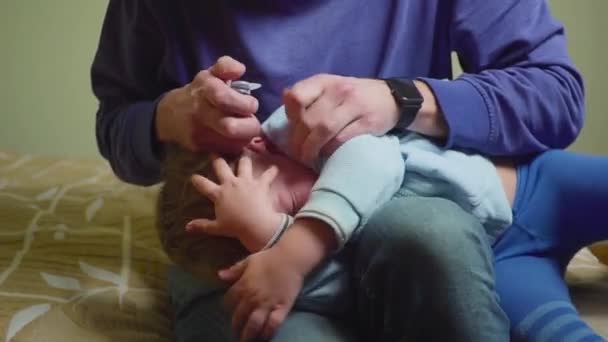 Close up father drips medicine into the ear of a sick boy. - Video, Çekim