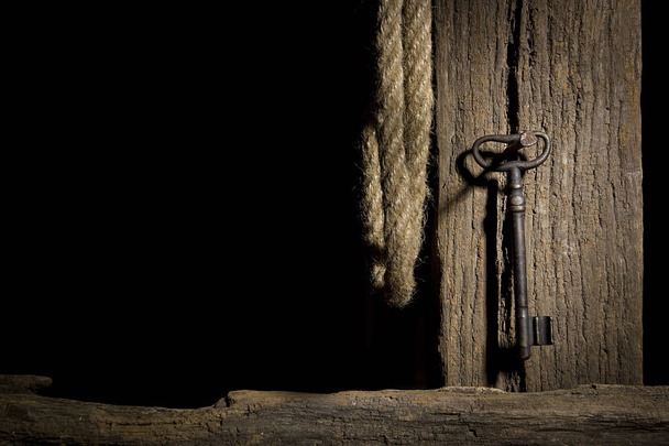 Винтажный ключ висит на старом бревне
 - Фото, изображение
