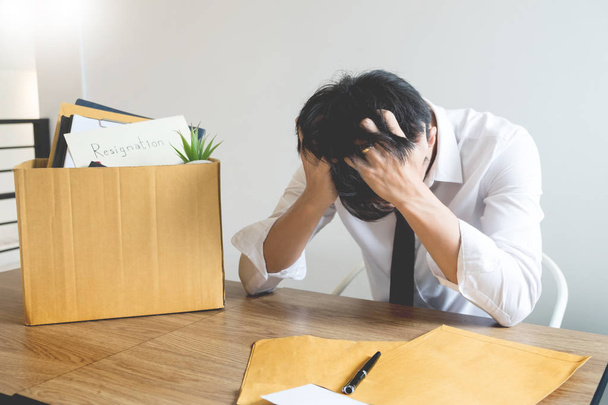 Businessmen are holding resignation document and packing personal company on brown cardboard box changing work, unemployment or resign concept. - Photo, Image