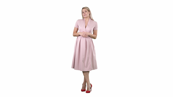 Blonde woman in pink clothes talking to camera on white background. - Footage, Video