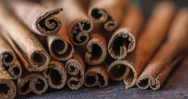 Cinnamon sticks on the dark wood table. - Photo, Image
