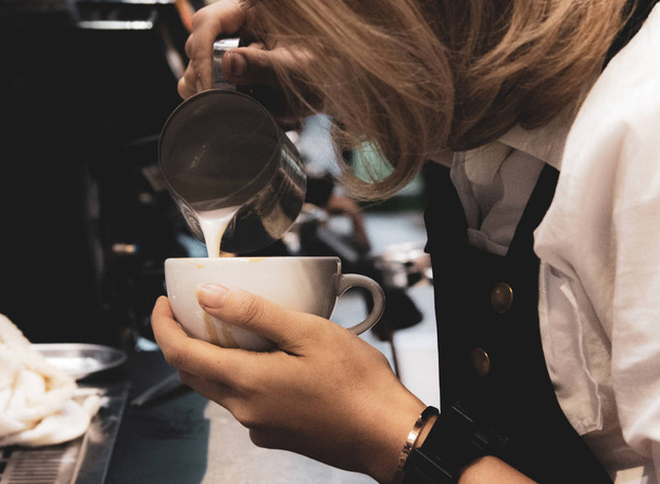 Barista vertiendo leche en el café, Barista haciendo café con arte latte
 - Foto, imagen